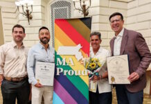 Senator Edwards and Representative Madaro celebrate Inaugural Commonwealth Pride Awardees Four people pose with a bright MA Proud banner; two hold official certificates and one carries a bouquet of sunflowers.