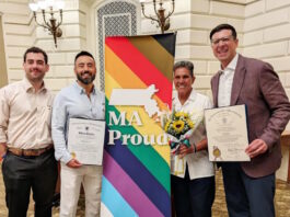 Senator Edwards and Representative Madaro celebrate Inaugural Commonwealth Pride Awardees Four people pose with a bright MA Proud banner; two hold official certificates and one carries a bouquet of sunflowers.