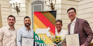 Senator Edwards and Representative Madaro celebrate Inaugural Commonwealth Pride Awardees Four people pose with a bright MA Proud banner; two hold official certificates and one carries a bouquet of sunflowers.