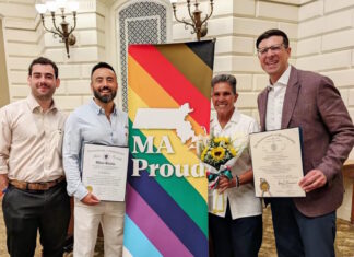 Senator Edwards and Representative Madaro celebrate Inaugural Commonwealth Pride Awardees Four people pose with a bright MA Proud banner; two hold official certificates and one carries a bouquet of sunflowers.