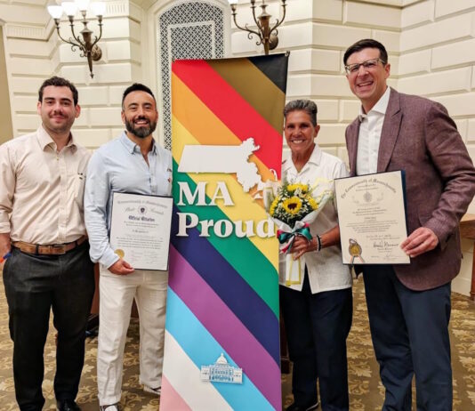 Senator Edwards and Representative Madaro celebrate Inaugural Commonwealth Pride Awardees Four people pose with a bright MA Proud banner; two hold official certificates and one carries a bouquet of sunflowers.