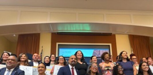 Latinos for Education Honors Brooke Charter School Multilingual Learner Coordinator Lesley Peรฑa Group of diverse professionals posing with certificates at an awards or graduation event in a conference room.