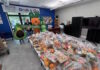 Maverick Landing Community Services launches Grab & Go produce market, expanding affordable fresh food access across East Boston Volunteers in avocado and carrot costumes pose behind tables stacked with grab-and-go produce bags at a community food drive.