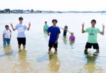 Two hundred fifty kids Boston kids had a blast at Save the Harborโs Annual Eastie Beach Bash Group of kids standing in knee-deep water at the beach, posing and making peace signs.