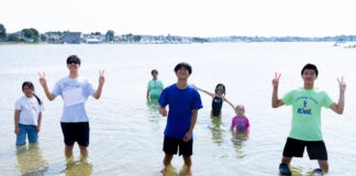 Two hundred fifty kids Boston kids had a blast at Save the Harborโs Annual Eastie Beach Bash Group of kids standing in knee-deep water at the beach, posing and making peace signs.